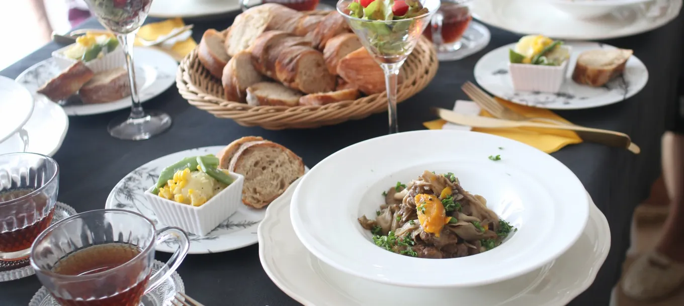 レッスンのランチ。パンのかご、メインの皿、サラダ、紅茶が食卓に並ぶ