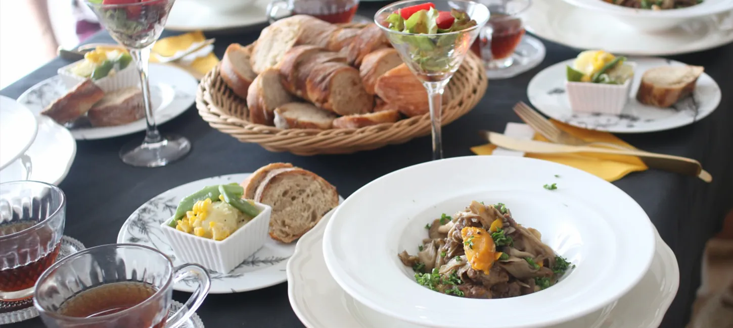 レッスンのランチ。パンのかご、メインの皿、サラダ、紅茶が食卓に並ぶ